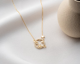 A zoomed-in image of the Saturn pendant necklace, highlighting its handcrafted details and fine sterling silver material.