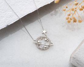 Minimalist planet necklace with a polished sterling silver Saturn pendant, inspired by the universe and space aesthetics.