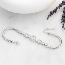 Silver bracelet on a white surface with lavender flowers