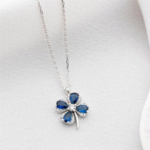 Blue four-leaf clover pendant necklace on a white background
