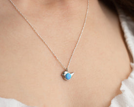 Handmade opal bird charm necklace in sterling silver, featuring a delicate celestial pendant.