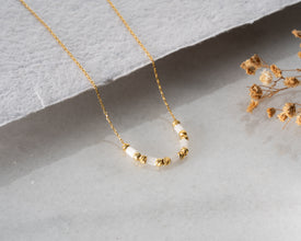 Close-up of white gemstone necklace on white background
