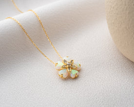 Elegant sterling silver floral necklace with an iridescent opal centerpiece, symbolizing renewal and beauty.