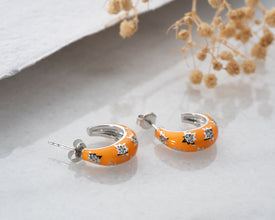 Close-up of sunset hoop earrings showing shimmering cosmic colors