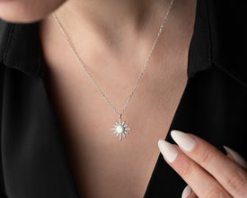 A silver moon necklace on a cosmic-themed background, perfect for zodiac lovers and spiritual seekers.