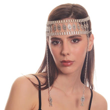 Woman wearing a silver headband with dangling chains on a white background