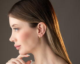 Yoga instructor demonstrating downdog with glinting lotus earrings