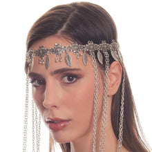 Woman wearing a silver headpiece with chains on a white background
