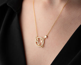 A woman wearing an astrology-inspired silver Saturn necklace, styled with celestial and cosmic-themed accessories.