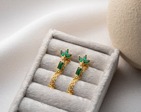 Gold lotus chain earrings styled with boho bridal accessories on lace fabric