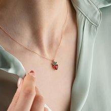 Necklace with a strawberry pendant worn by a person