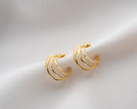 Gold layered hoop earrings with CZ accents styled with minimalist stackable bracelets