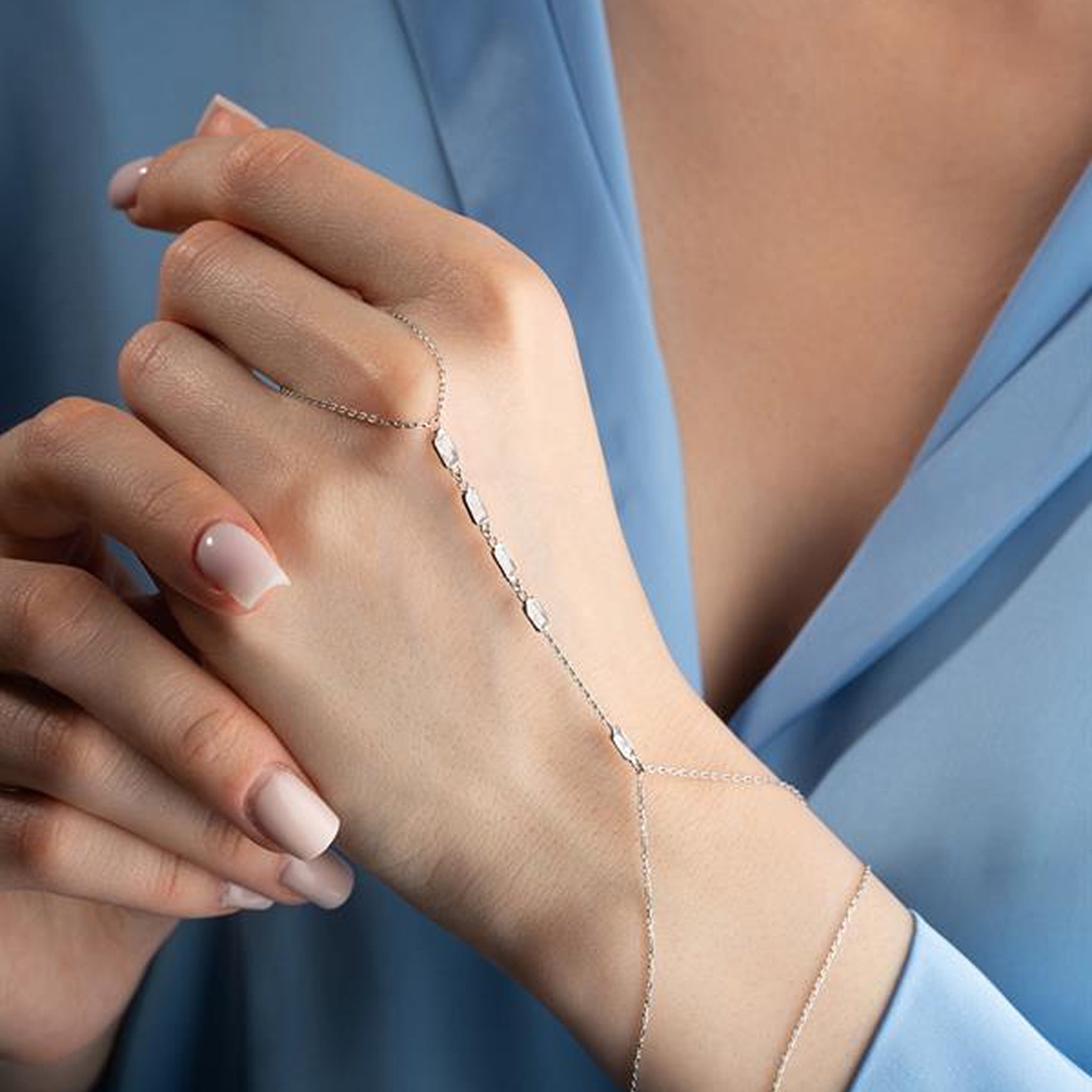 Close-up of a hand wearing a delicate bracelet with a soft focus background