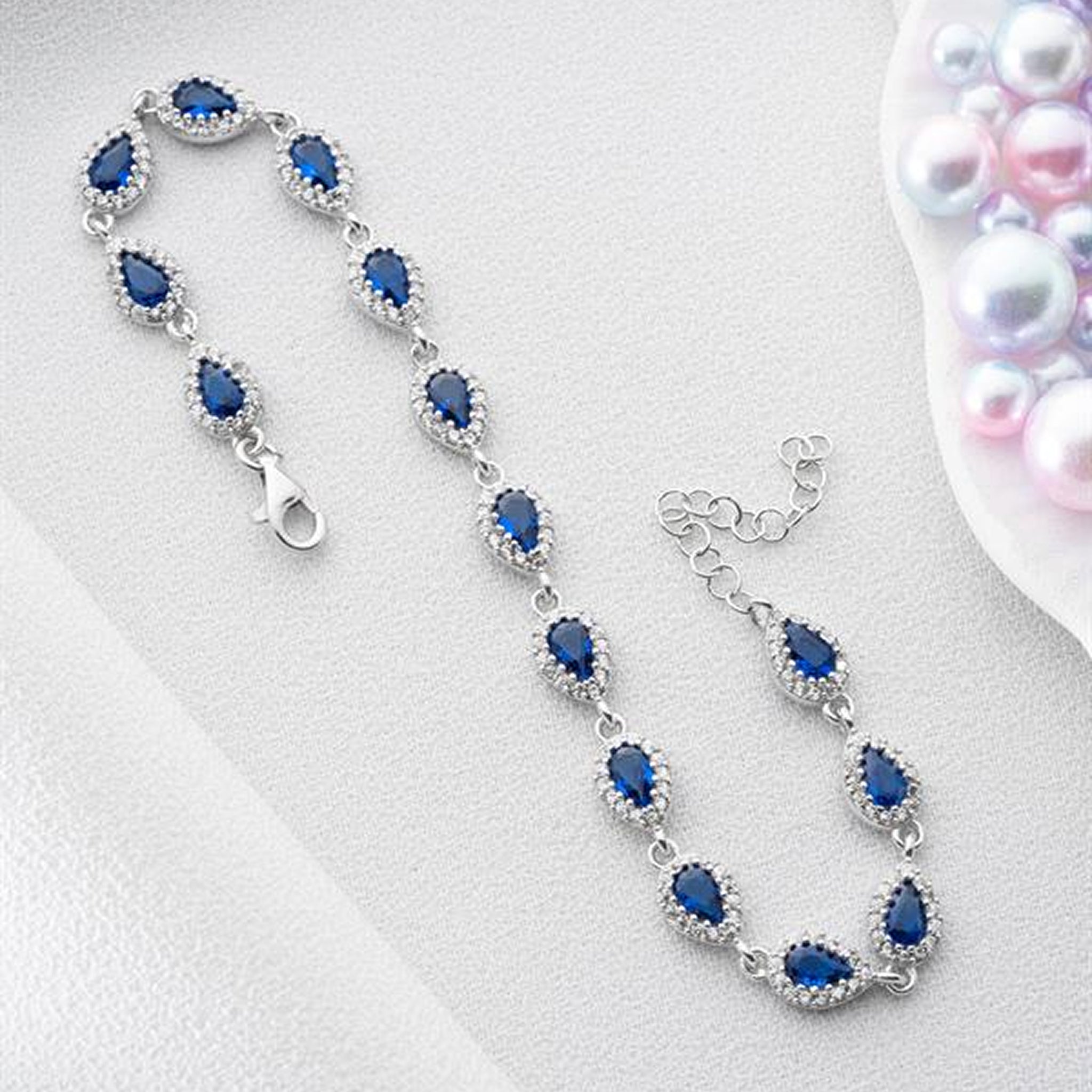 Silver bracelet with blue gemstones on a light gray background