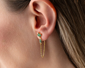 Yoga instructor wearing lotus earrings in downward dog pose during class