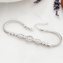Silver bracelet with intricate design on a light background