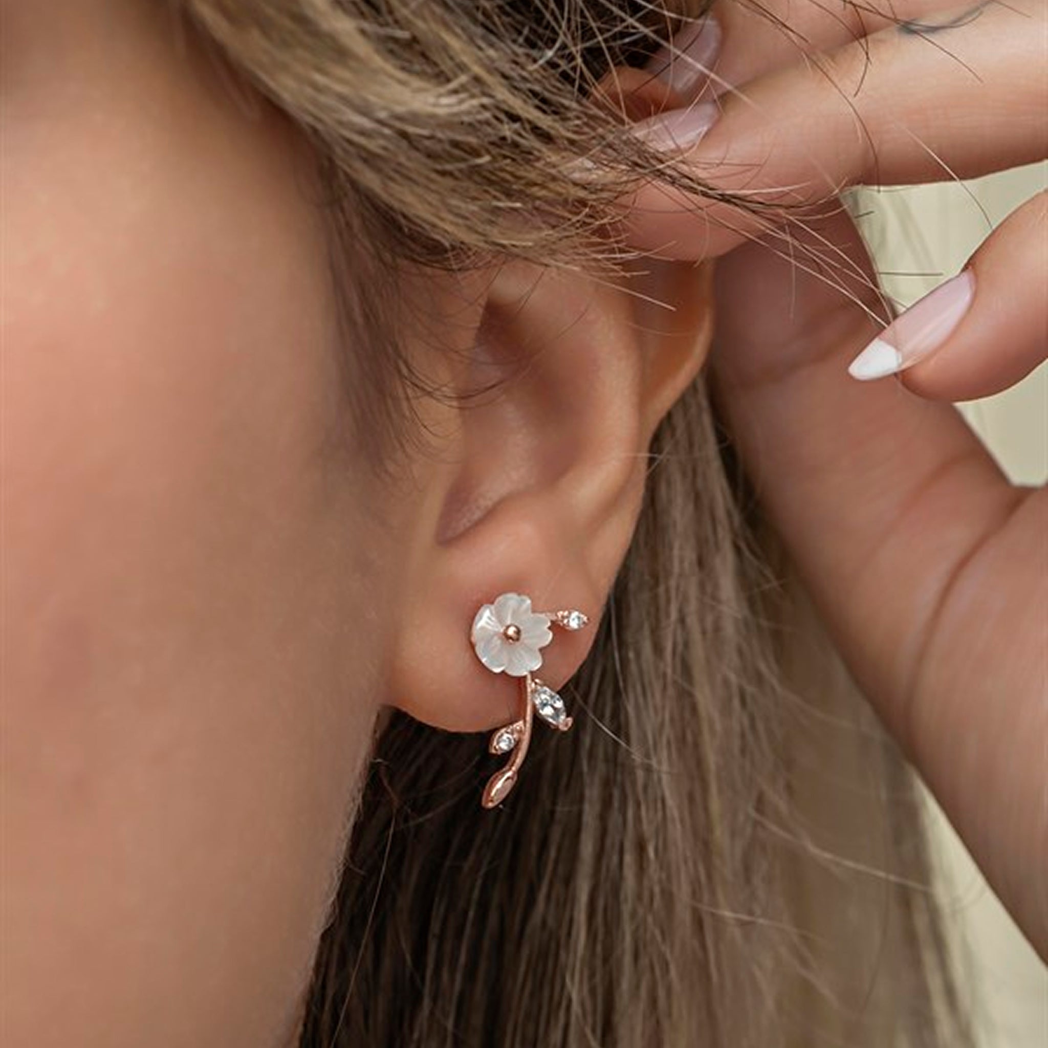 Close-up of a woman wearing a delicate floral earring.