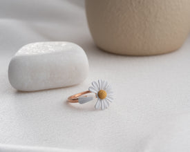 Moonlit flatlay of petal ring on poetry journal