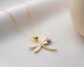 Dragonfly and Evil Eye necklace styled with natural elements