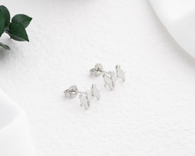 Tiny bird-shaped stud earrings in sterling silver, designed for everyday wear.