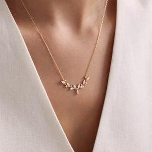 Delicate gold necklace on a white blouse