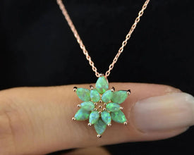 Unique handcrafted jewelry piece with a lotus design and fire opal accent.