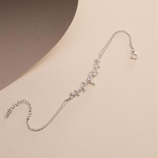 Silver bracelet with floral design on a beige background