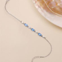 Silver bracelet with blue gemstones on a beige background