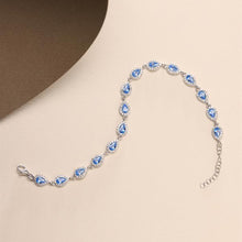 Silver bracelet with blue gemstones on a beige background