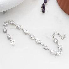 Silver bracelet with clear stones on a white surface