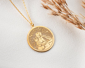 A close-up of a handcrafted silver necklace inspired by The Little Prince story.