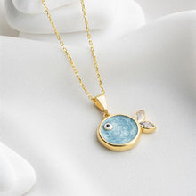 Gold necklace with a blue pendant on a white background