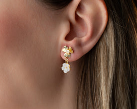 Bridal flatlay featuring gold floral earrings with mother-of-pearl on silk