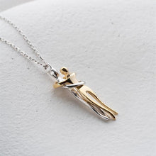 Gold and silver pendant necklace on a light gray background