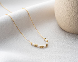 White gemstone gold bead necklace shown from the front