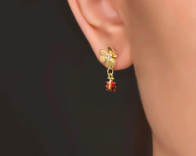 Handmade gold-plated flower and ladybug dangle earrings, nature-inspired design.