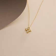 Gold necklace with a butterfly pendant on a beige background