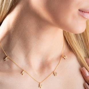 Gold necklace with small pendants on a person's neck