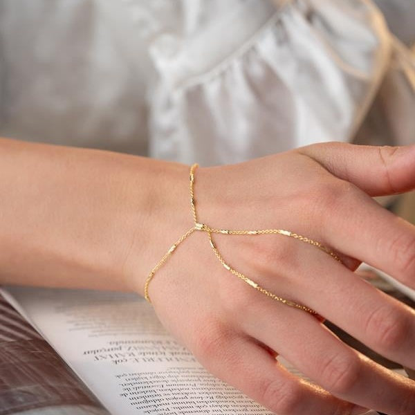 Gold bracelet on a person's wrist with a blurred background