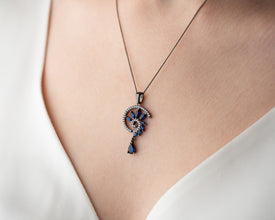 Victorian goth outfit with sapphire necklace and high-neck blouse