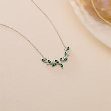 Necklace with green gemstones on a beige background