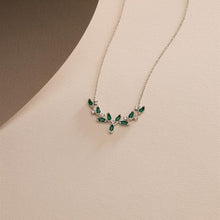 Necklace with green gemstones on a beige background