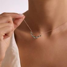 Necklace with green gemstones being worn on a person's neck