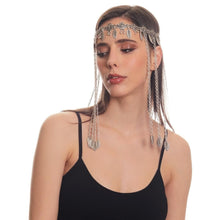 Woman wearing a decorative headpiece with chains on a white background