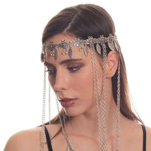 Woman wearing a silver headpiece with chains on a white background