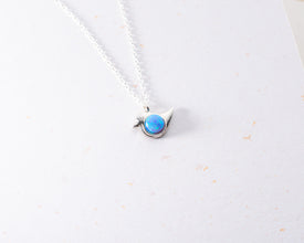 Handcrafted sterling silver bird necklace featuring an ethereal opal gemstone centerpiece.