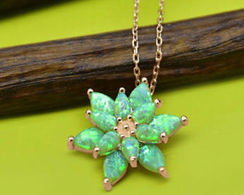 Handmade green opal lotus pendant necklace in sterling silver, featuring a delicate fire opal gemstone.