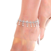 Silver anklet on a person's ankle with sheer white stockings.
