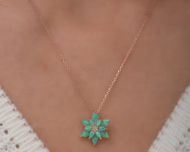  A sterling silver lotus flower necklace with an elegant green opal gemstone, symbolizing balance and renewal.