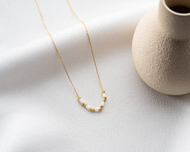 Woman wearing gold bead necklace with a casual outfit